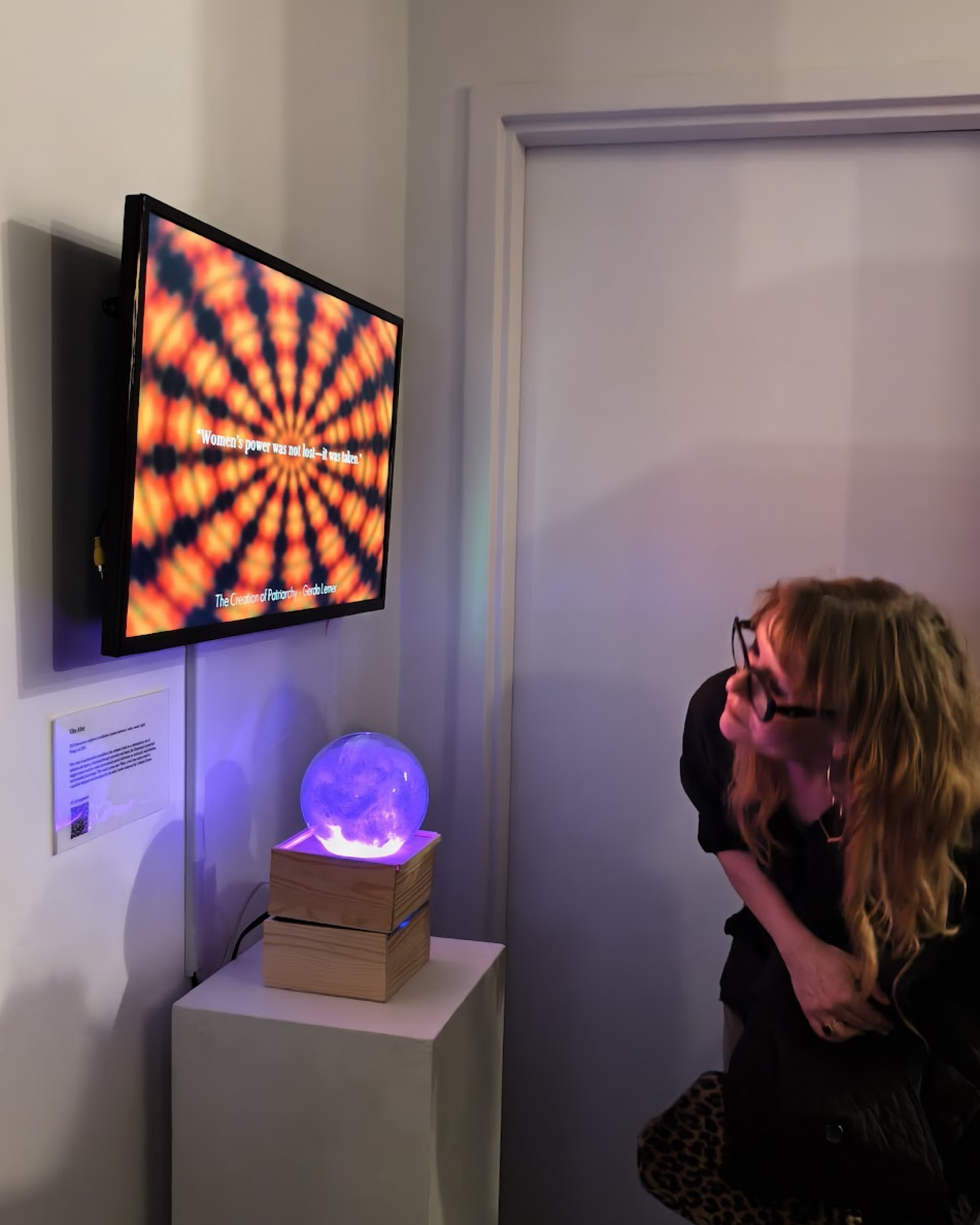 Gallery visitor approaching Vibe Altar crystal ball at Every Woman Biennial opening night